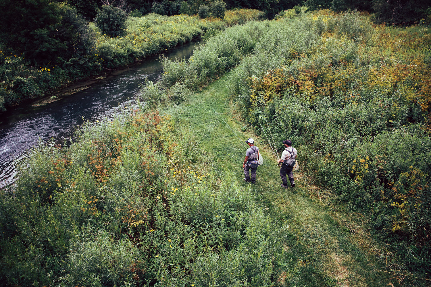 Drone image looking down on Bret and a client walking toward a river