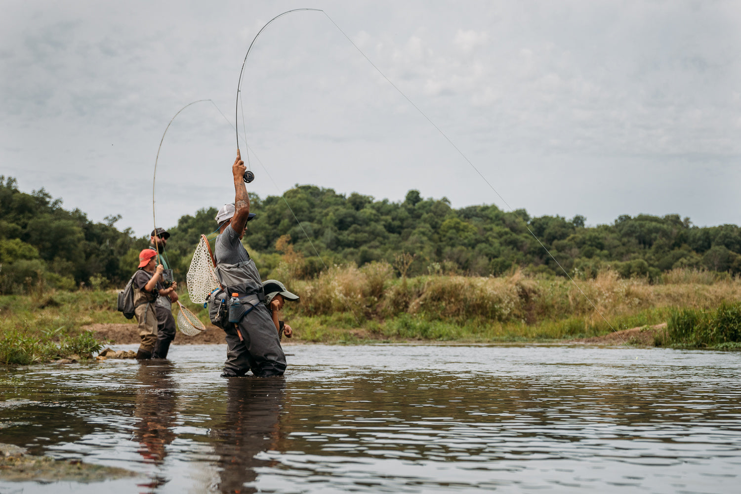 Image of Bret with 1 adult and 2 children clients wading in the river and casting